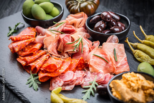 Photos Platter of antipasti with a mixture of salami, prosciutto, bocconcini, peppers,