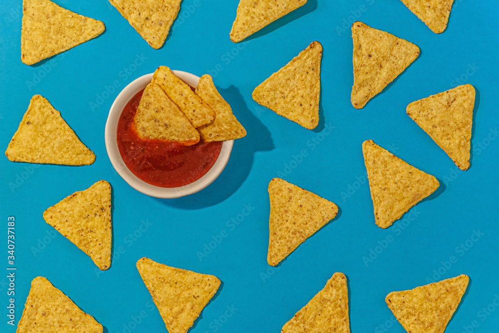 nachos chips with chili sauce on a blue background close up nachos chips with chili sauce on a blue background close up