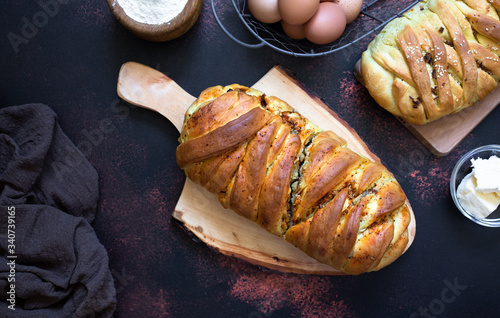 A traditional salty pie of Russian cuisine called kulebyaka. Ingredients for the dough butter, flour, eggs. Dark rustic background. Top view photo