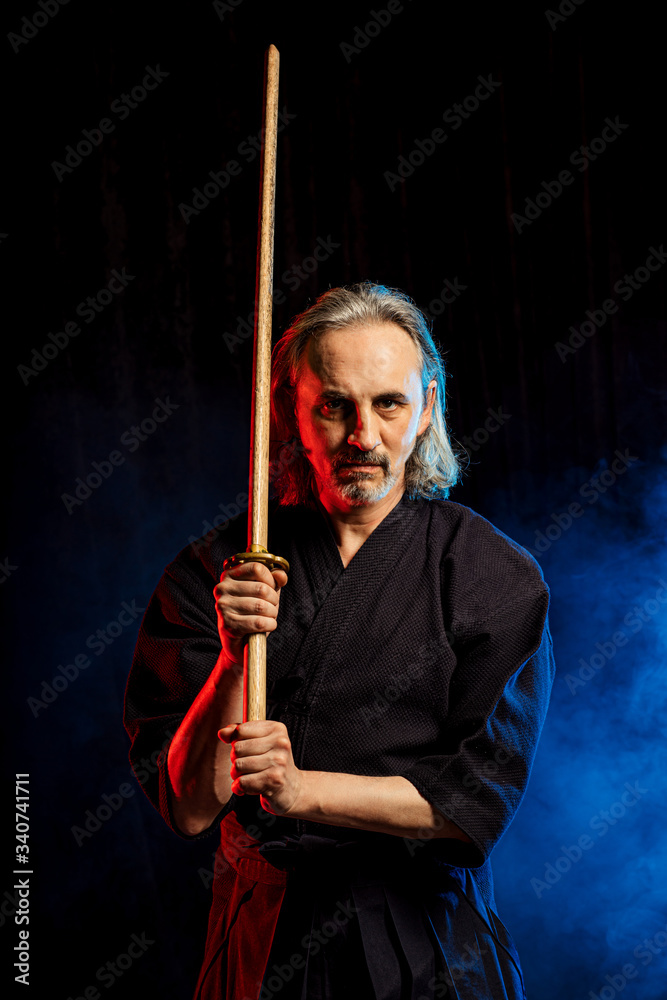 caucasian male kendo fighter with bamboo sword shinai . traditional japanese martial art as hobby. samurai