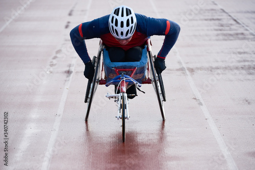 Paraplegic male athlete training speed while racing in sport wheelchair