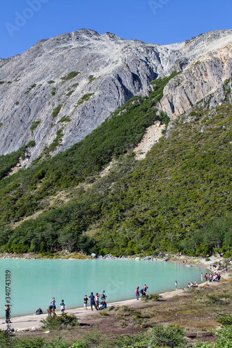Gente disfrutando en un lago entre montañas en un día soleado