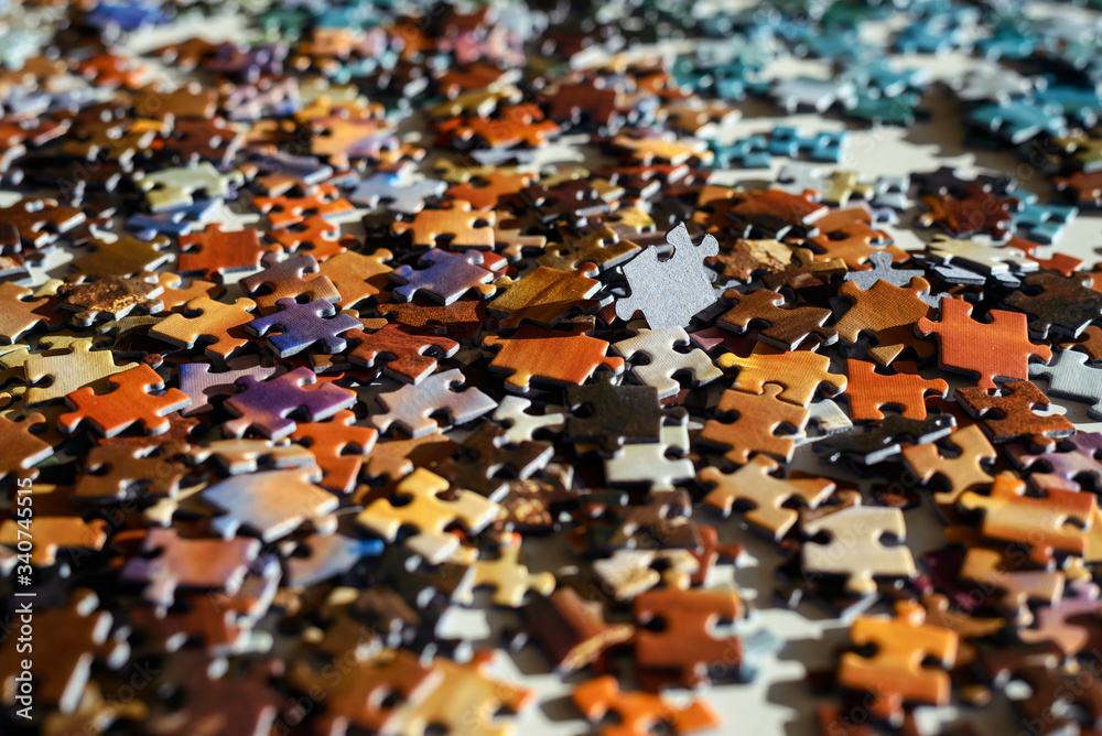 Scattered jigsaw puzzle pieces in natural colors. Laying on table in sun  light. Concept of messy and chaotic. Stock Photo | Adobe Stock