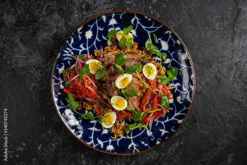 Food dish. Beans, rice, meat, salad, egg. Rustic wood background.