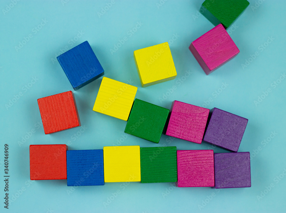 colorful wooden cubes scattered on a blue background