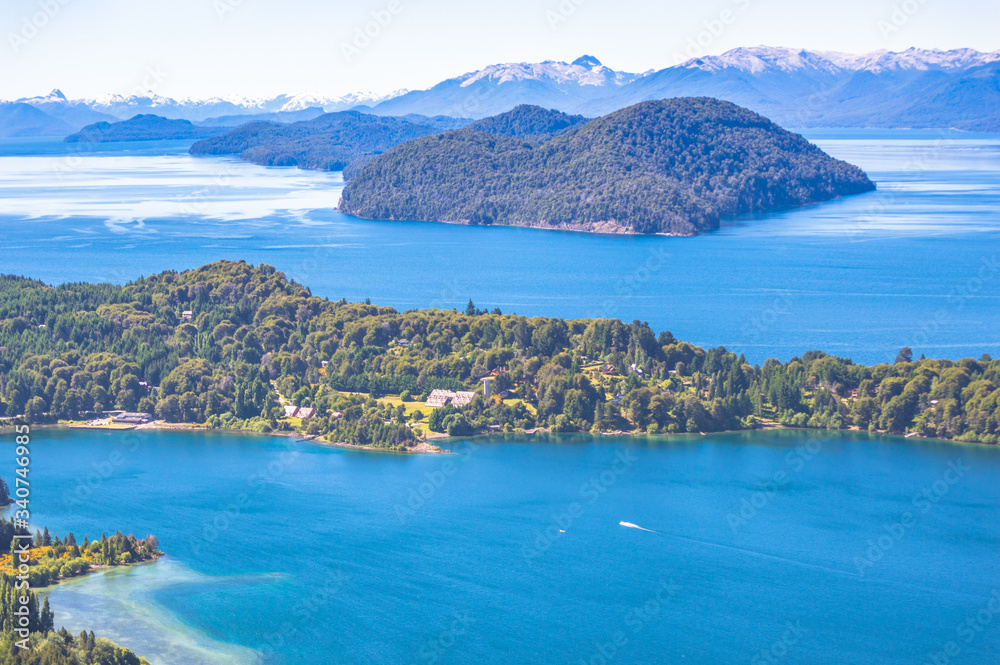 Andean lakes with mountains around blue sky and green vegetation in Argentine Patagonia in Bariloche