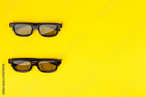 Top view of two 3D glasses on a yellow background