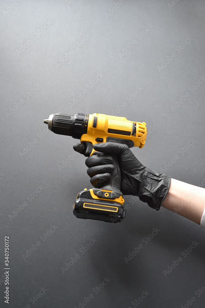 screwdriver in a female hand in a glove on a black background