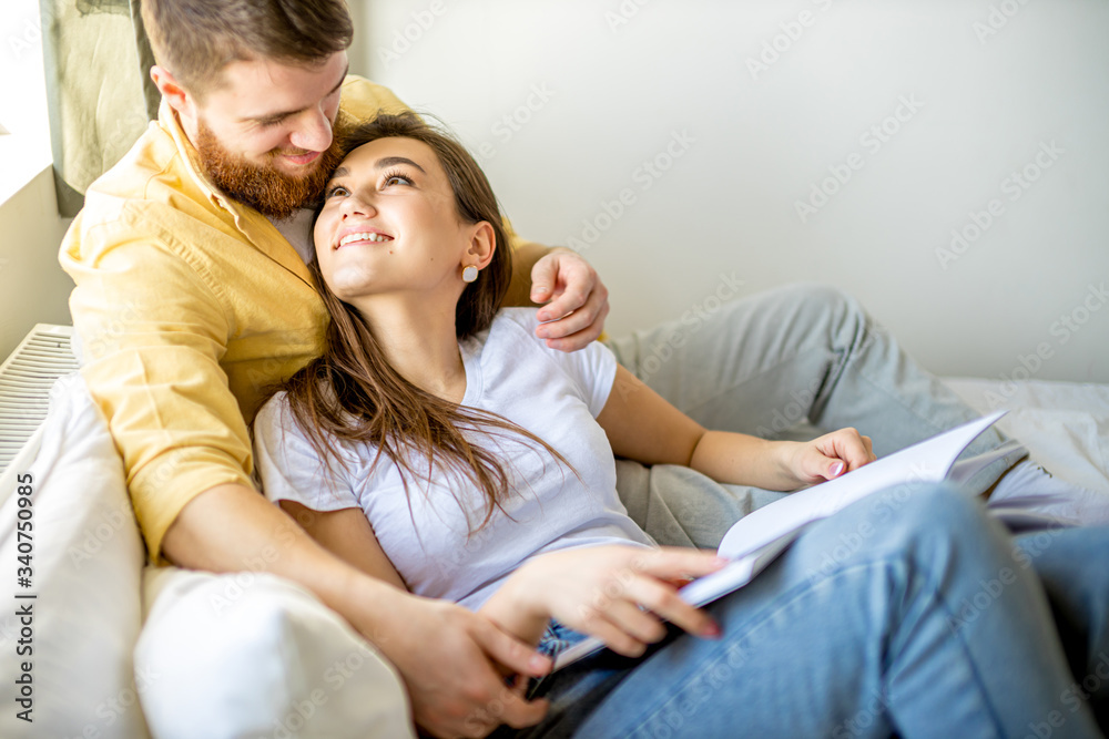 young and beautiful caucasian couple have rest together at home, happy man and woman lie on bed and read a book, harmonious relationships young and beautiful caucasian couple have rest together at home, happy man and woman lie on bed and read a book, harmonious relationships