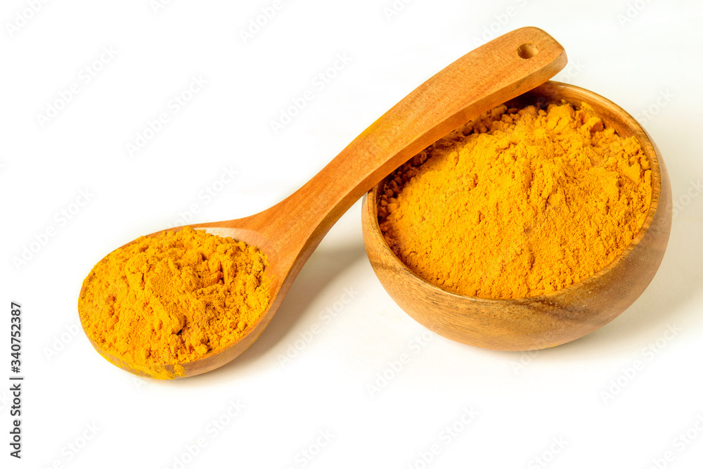 Turmeric powder in wooden spoon and bowl on the white background closeup isolated. Healing spice, health care concept. Turmeric powder in wooden spoon and bowl on the white background closeup isolated. Healing spice, health care concept.