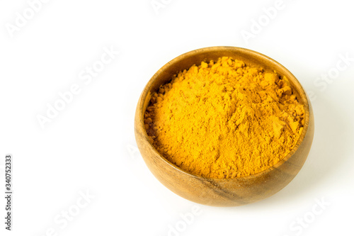 Turmeric powder in wooden bowl on the white background isolated closeup. Alternative medicine, healing spice, health care concept.