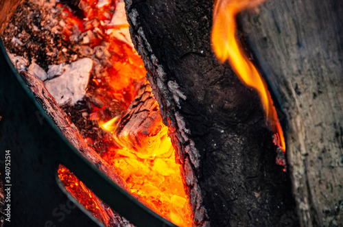 THE RED EMBERS OF A CAMPFIRE IN THE WOOD AT NIGHT