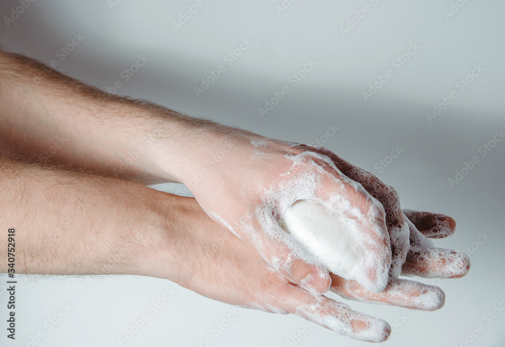 Fototapeta premium Washing hands with soap. Medical and pharmaceutical concept. Protection against viruses, bacteria, germs. Washing hands with antibacterial soap, getting rid of dirt, fighting an epidemic.