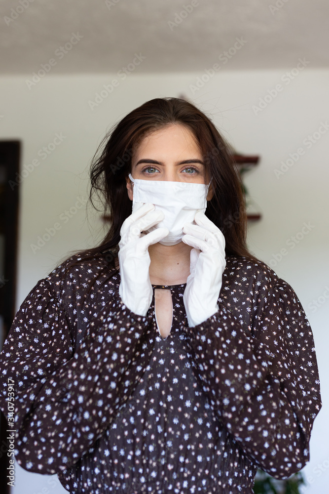portrait of beautiful young woman wearing cotton white mask and medical/surgical gloves on white background. portrait of beautiful young woman wearing cotton white mask and medical/surgical gloves on white background.