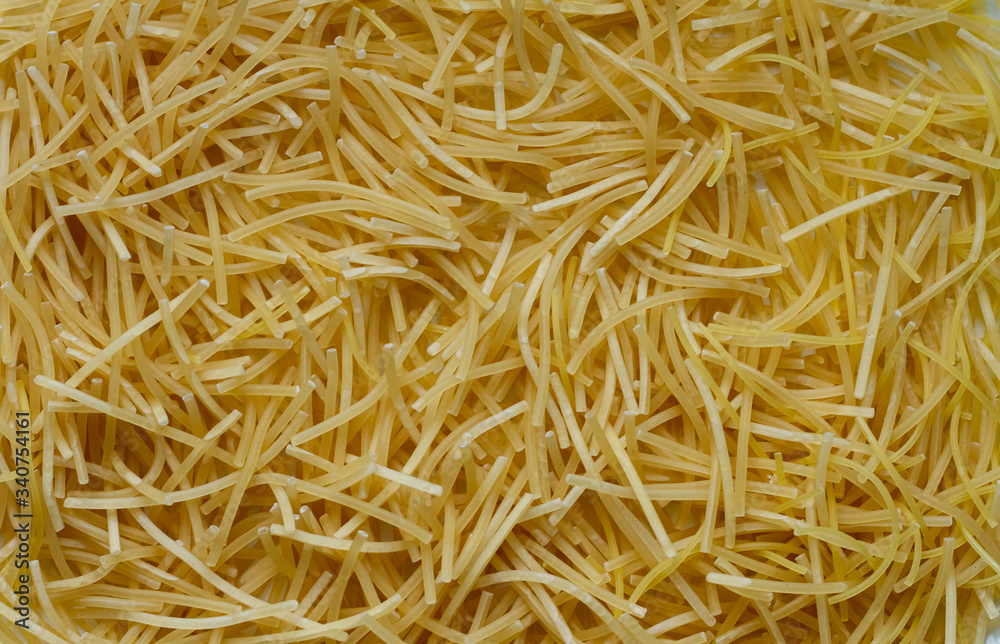 Thin little noodles, a kind of Italian pasta as a food background or texture.