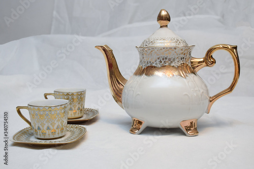 Mock up / design set of elegant and traditional teapot colorful white blue gold coffee cup & Tea cup on cup's plate beside the hot tea pot , design/ drink-ware isolated on white background