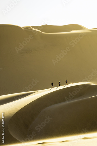 Children running, playing and climbing up on dune 7 in namibia desert