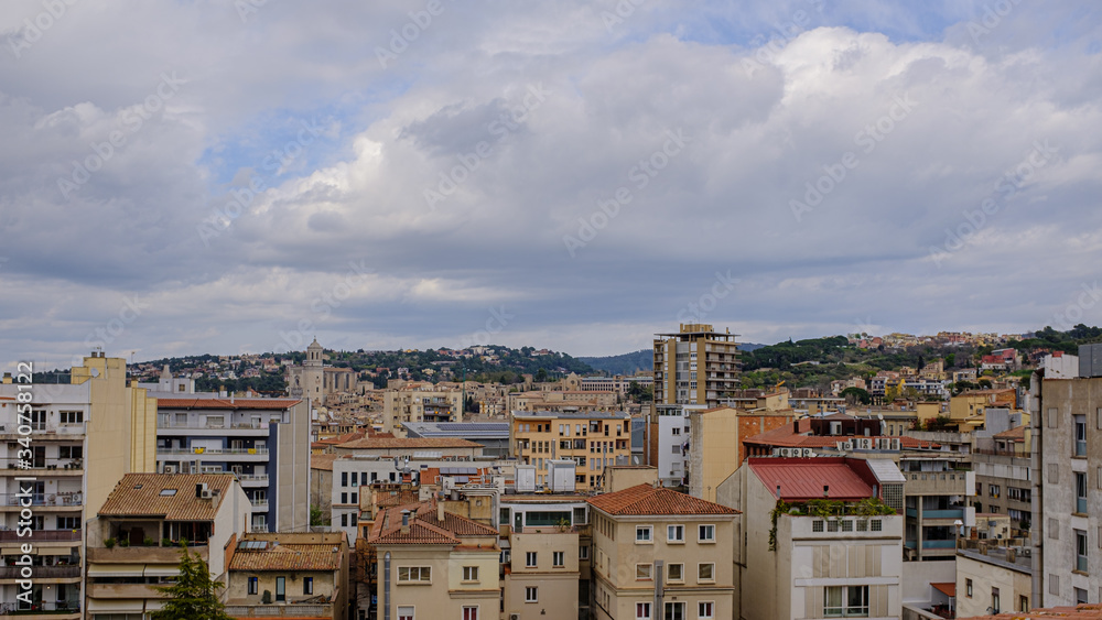 Girona city skyline from a rooftop on a cloudy day with many urban buildings with bricks ceiling