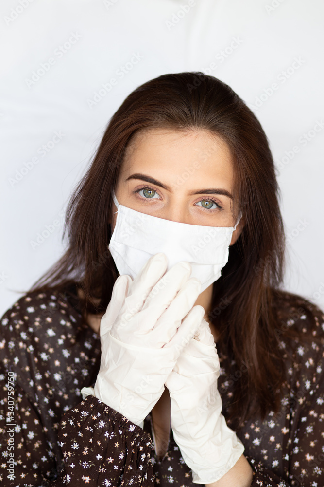 portrait of beautiful young woman wearing cotton white mask and medical/surgical gloves on white background. portrait of beautiful young woman wearing cotton white mask and medical/surgical gloves on white background.