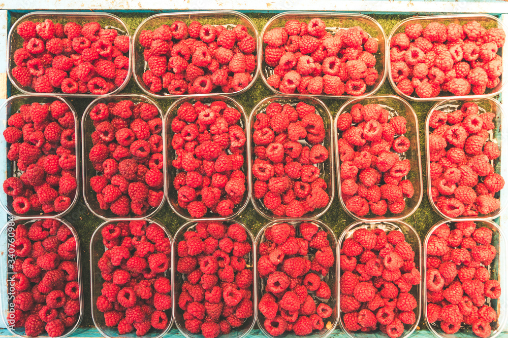 Array of bowls or shells of juicy raspberries on a local street market in stockholm