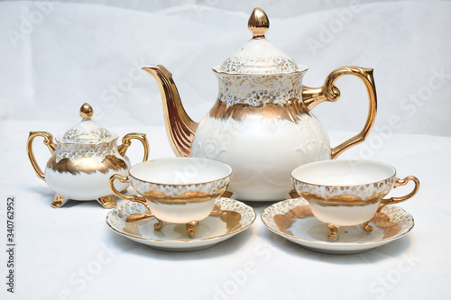 Mock up / design set of elegant and traditional teapot colorful white blue gold coffee cup & Tea cup on cup's plate beside the hot tea pot , design/ drink-ware isolated on white background