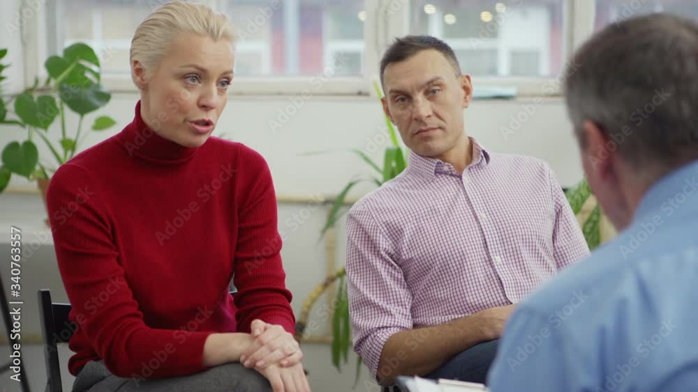 Selective focus of middle aged couple having session with experienced counselor and telling about their problems Selective focus of middle aged couple having session with experienced counselor and telling about their problems
