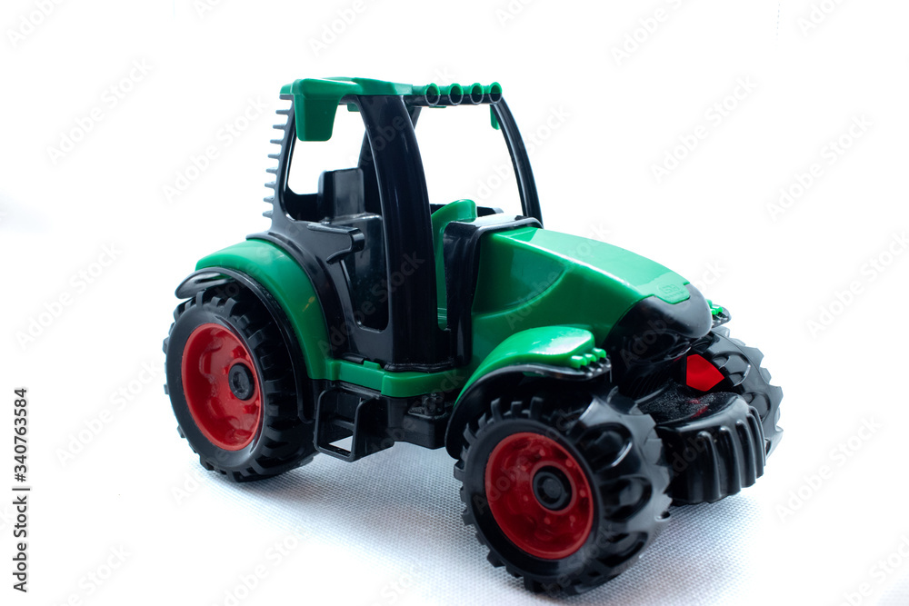 A child's plastic toy tractor isolated on a white background A child's plastic toy tractor isolated on a white background