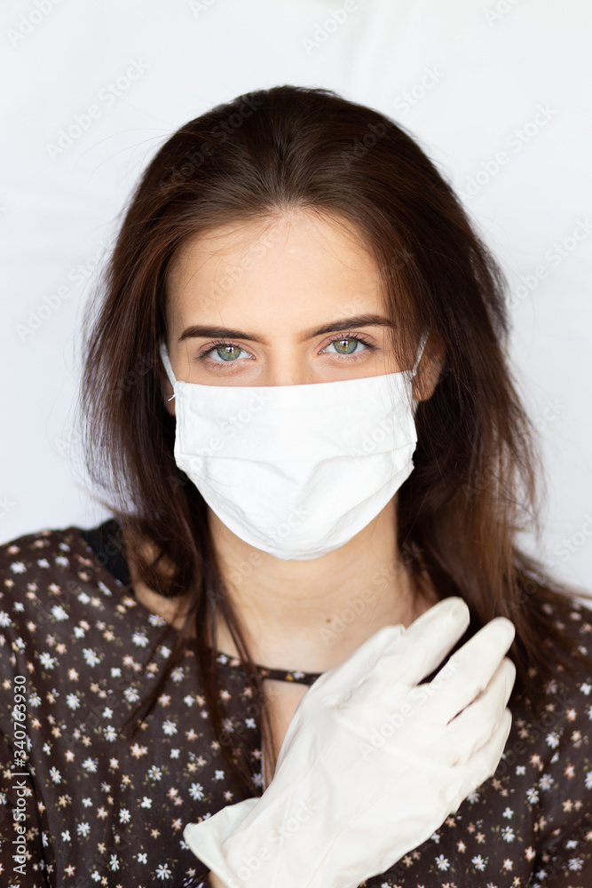 portrait of beautiful young woman wearing cotton white mask and medical/surgical gloves on white background. portrait of beautiful young woman wearing cotton white mask and medical/surgical gloves on white background.