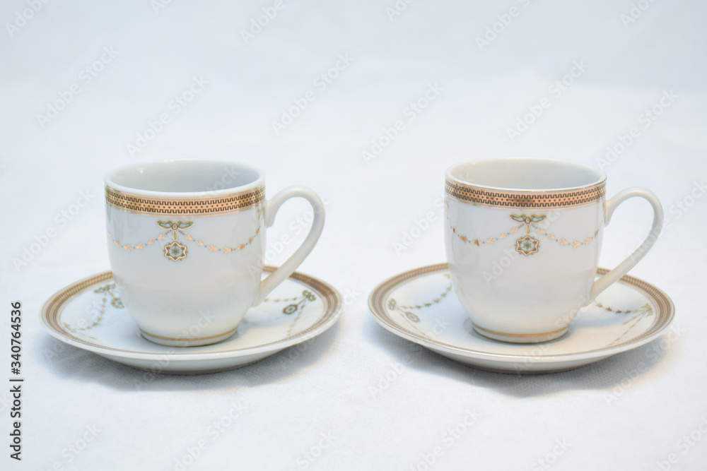 Mock up / design set of elegant and traditional teapot colorful white blue gold coffee cup & Tea cup on cup's plate beside the hot tea pot , design/ drink-ware isolated on white background Mock up / design set of elegant and traditional teapot colorful white blue gold coffee cup & Tea cup on cup's plate beside the hot tea pot , design/ drink-ware isolated on white background