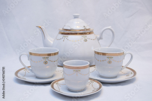 Mock up / design set of elegant and traditional teapot colorful white blue gold coffee cup & Tea cup on cup's plate beside the hot tea pot , design/ drink-ware isolated on white background