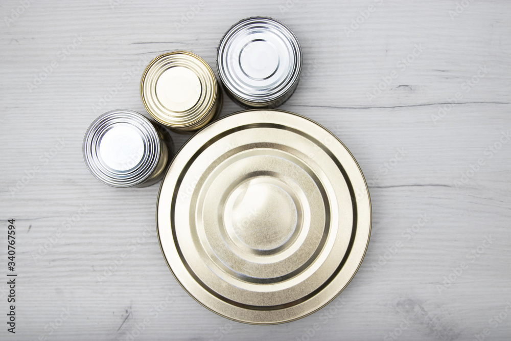 Various closed tin cans with food preserves on a light background. Canned food concept. Food donations. Copy space. Various closed tin cans with food preserves on a light background. Canned food concept. Food donations. Copy space.