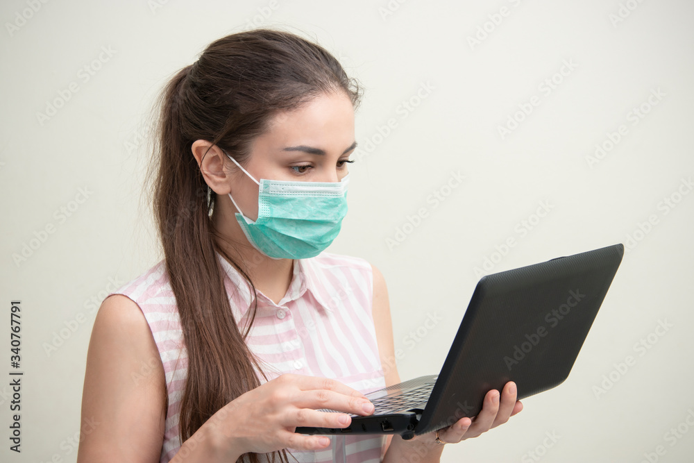 Coronavirus. Young business woman working from home wearing protective mask, Online training education and freelance work.. Working from home. Coronavirus. Young business woman working from home wearing protective mask, Online training education and freelance work.. Working from home.