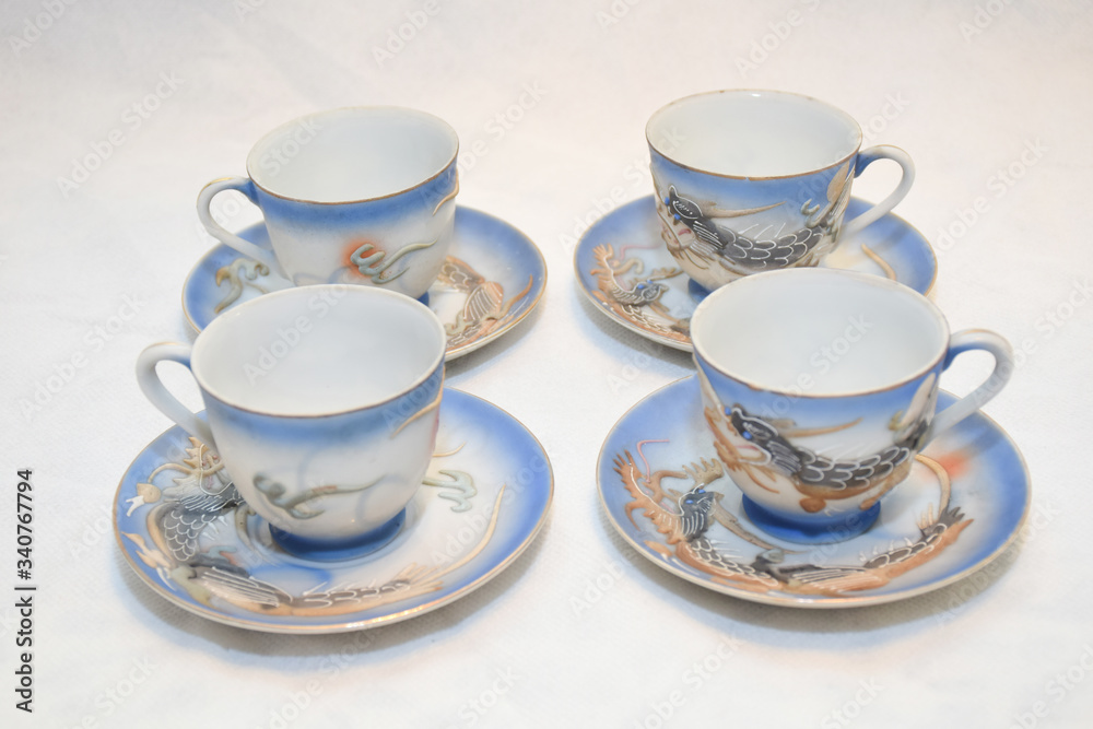 Mock up / design set of elegant and traditional teapot colorful white blue gold coffee cup & Tea cup on cup's plate beside the hot tea pot , design/ drink-ware isolated on white background Mock up / design set of elegant and traditional teapot colorful white blue gold coffee cup & Tea cup on cup's plate beside the hot tea pot , design/ drink-ware isolated on white background