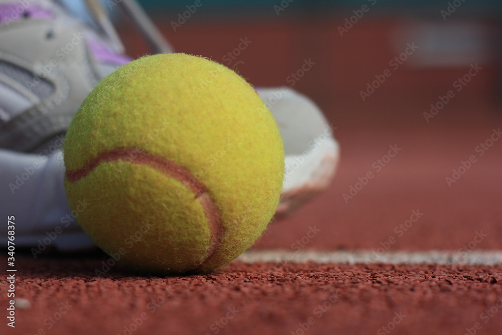 tennis ball on court whit shoes