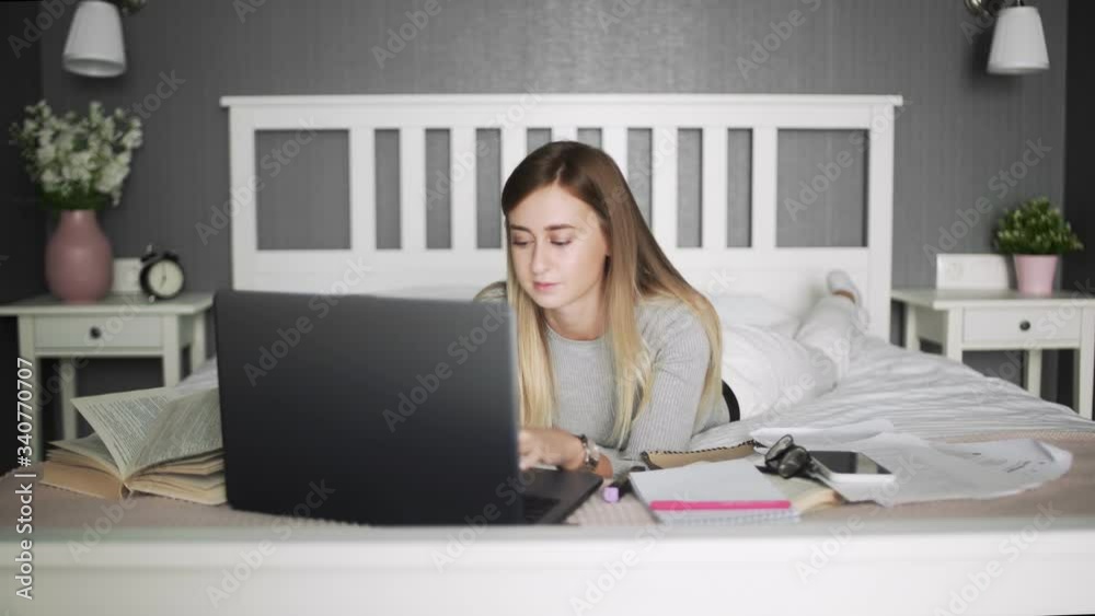 Woman lying on the bed using notebook. Freelance, work at home, work outside the office. Woman lying on the bed using notebook. Freelance, work at home, work outside the office.