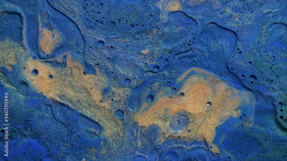 Colorful gold dust acrylic paint spreading on blue watercolor surface mix in fantastic design and textures. Sparkling golden particles, ink drops and mixing. Multicolored liquid background Colorful gold dust acrylic paint spreading on blue watercolor surface mix in fantastic design and textures. Sparkling golden particles, ink drops and mixing. Multicolored liquid background