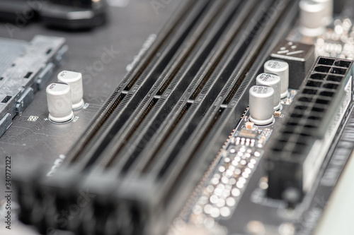 Closeup on empty RAM slots on a modern black silver motherboard. Random access memory stick slots. Macro of electronics and technology, simple pc components, shallow dof
