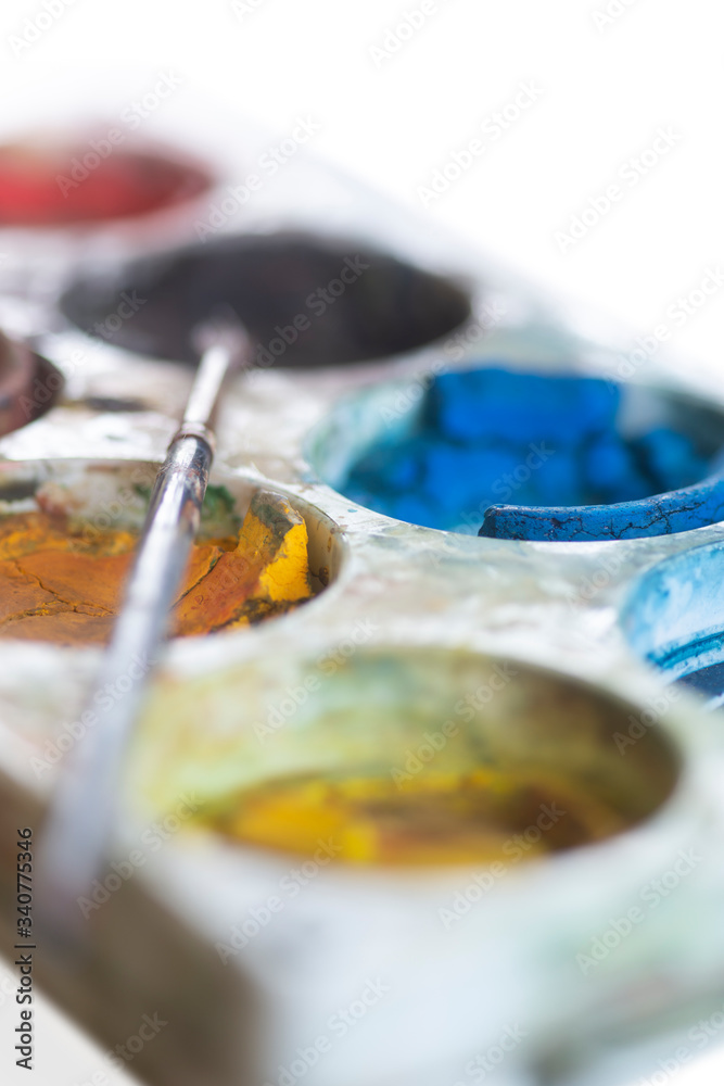 Close up of plastic watercolor plette box with paintbrush Close up of plastic watercolor plette box with paintbrush