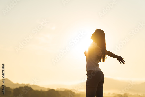 Silhouette of happy woman spreading arms and watching the mountain. Travel Lifestyle success concept adventure active vacations outdoor freedom emotions. photo