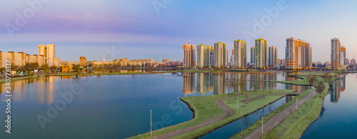 City panorama in the early morning. Residential building next to the ponds. Walking area with lakes next to the new residential complex. Modern housing construction. Apartments in new buildings.