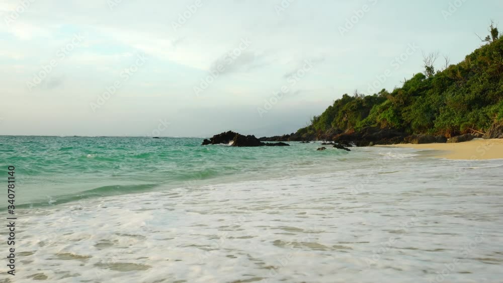 Background of sea sand beach which have movement wave of sea foam in tropical sunlight, Romantic peace and relax wide scene of a blue aqua menthe sea and summer season with copy space.