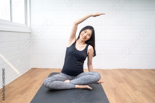Beautiful asian pregnant woman lotus sitting bending arm stretching yoga pose training practicing breathing, healthy and fit motherhood feeling happy and strong, pregnancy expecting future new born