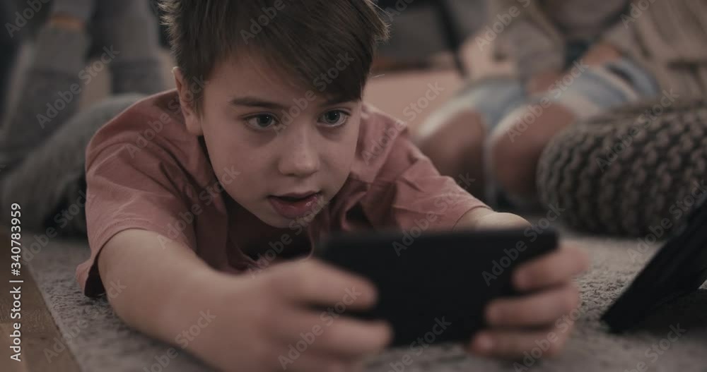 Little boy liveliy playing games on a smartphone stay at home virus pandemic outbreak extreme close up Little boy liveliy playing games on a smartphone stay at home virus pandemic outbreak extreme close up