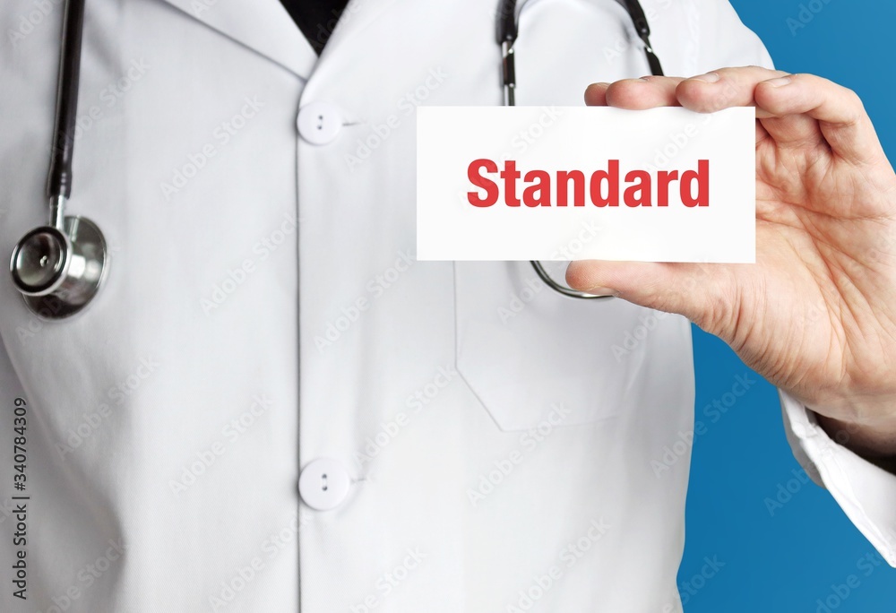 Standard. Arzt im Kittel hält Visitenkarte hoch. Der Begriff Standard steht im Schild. Symbol für Krankheit, Gesundheit, Medizin Standard. Arzt im Kittel hält Visitenkarte hoch. Der Begriff Standard steht im Schild. Symbol für Krankheit, Gesundheit, Medizin