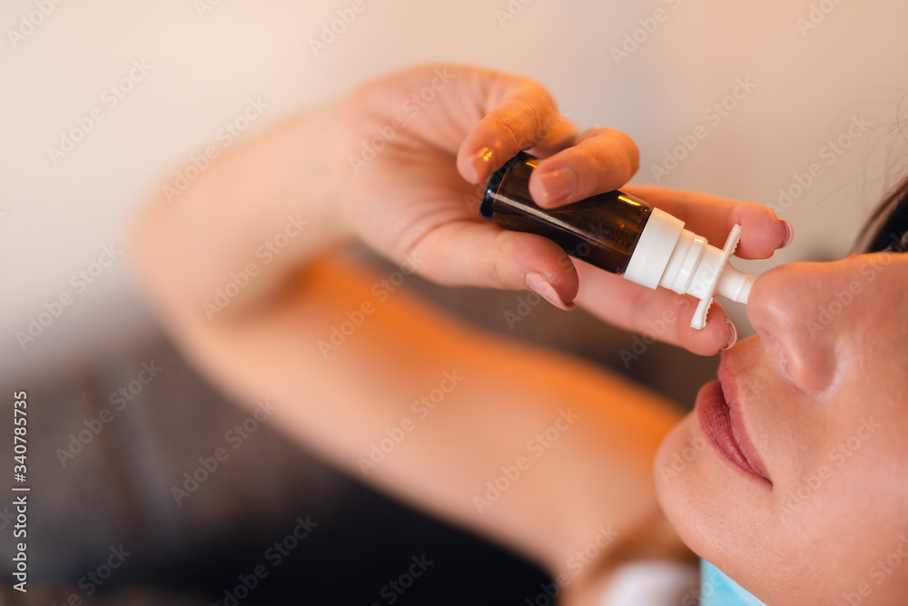 Sick caucasian girl with mask puts nose drops on Sick caucasian girl with mask puts nose drops on