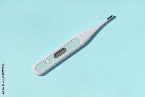 Medical electronic thermometer on blue background. Medicine, healthcare concept. 