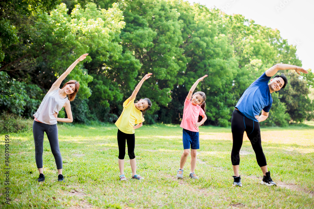 © Tom Wang - happy asian young family exercising  together at the park