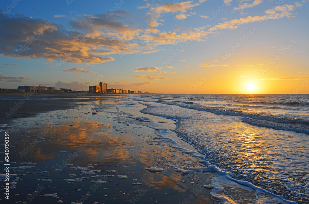 Naklejka premium Zachód słońca nad Morzem Północnym plaży Oostende (Ostenda w języku angielskim) i jego panoramę, Belgia.