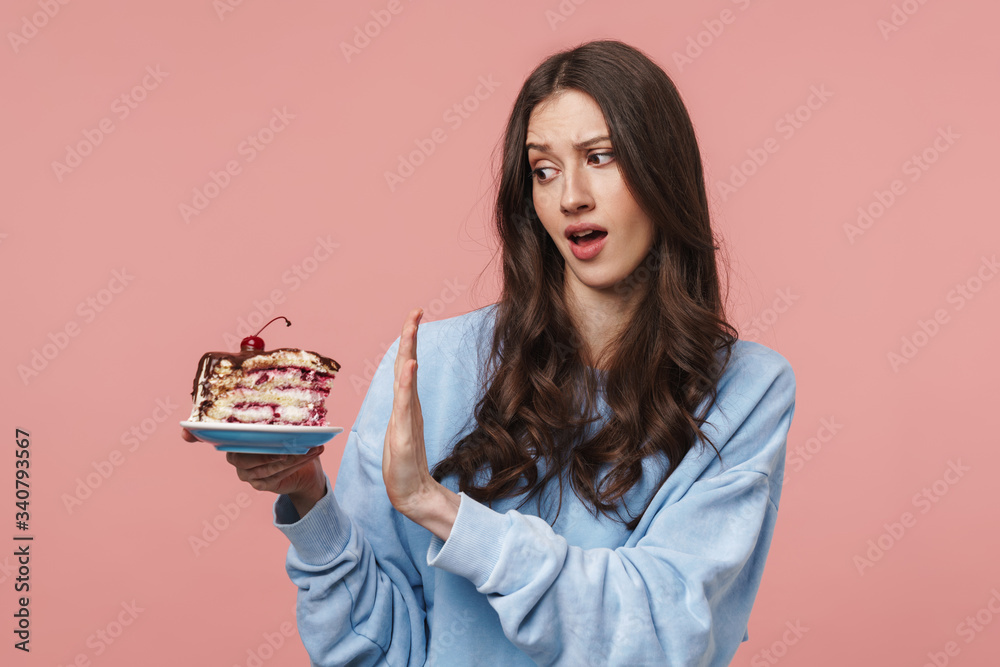 Image of displeased woman doing refusal gesture while holding cake Image of displeased woman doing refusal gesture while holding cake