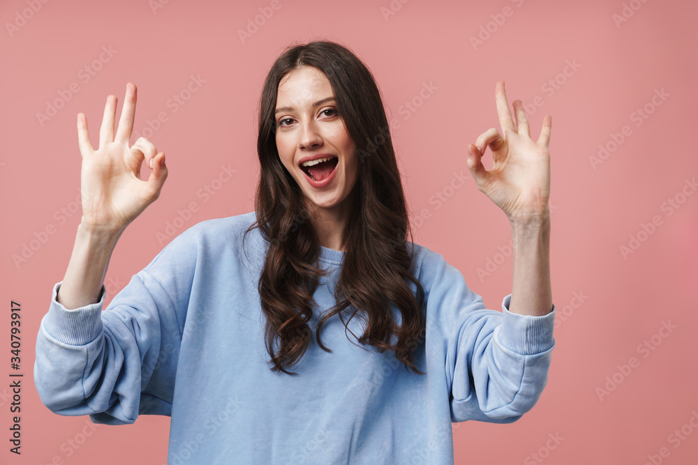 Image of attractive young woman smiling and gesturing okay sign Image of attractive young woman smiling and gesturing okay sign